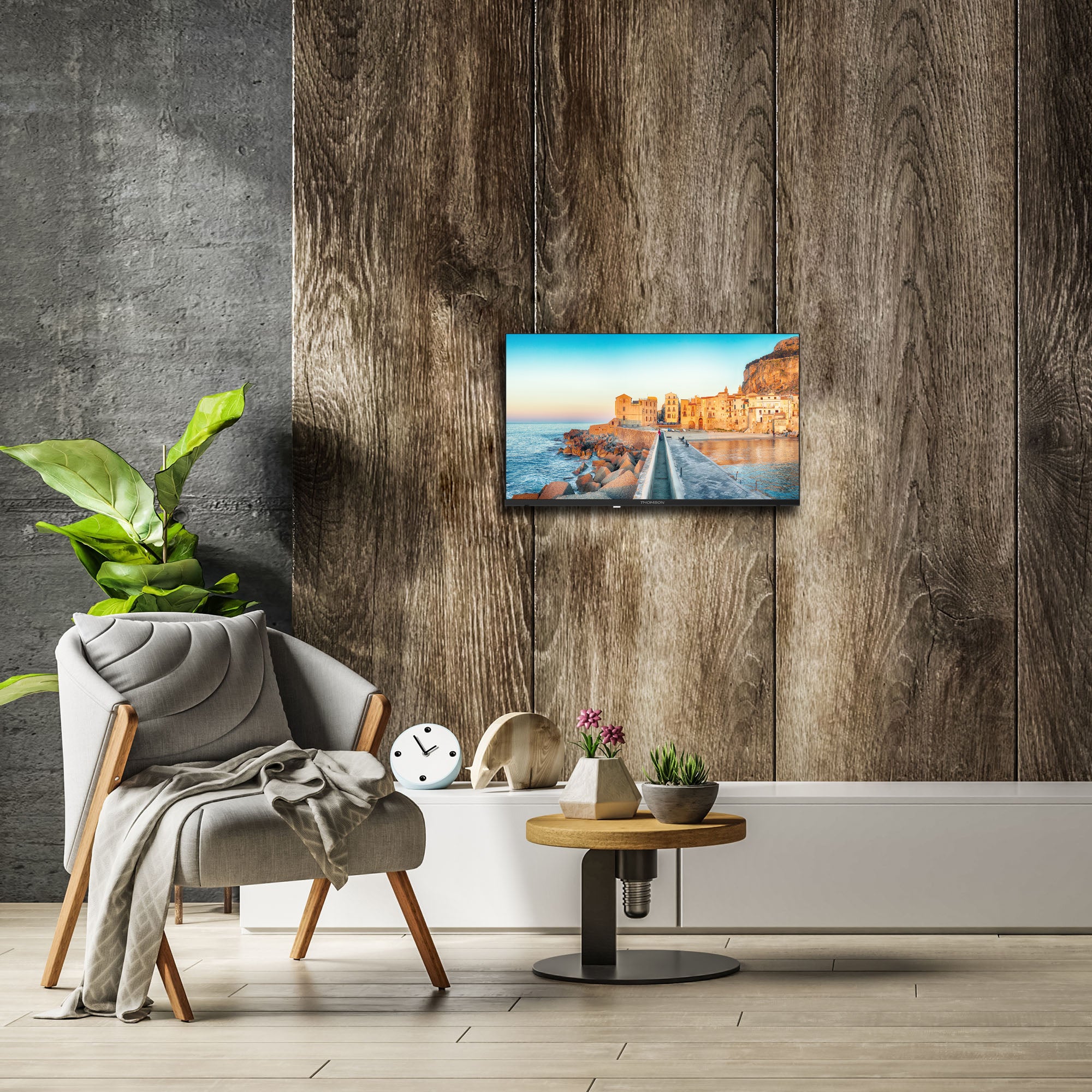 Modern living room with a Thomson TV displaying a scenic image, a chair, and decorative items.