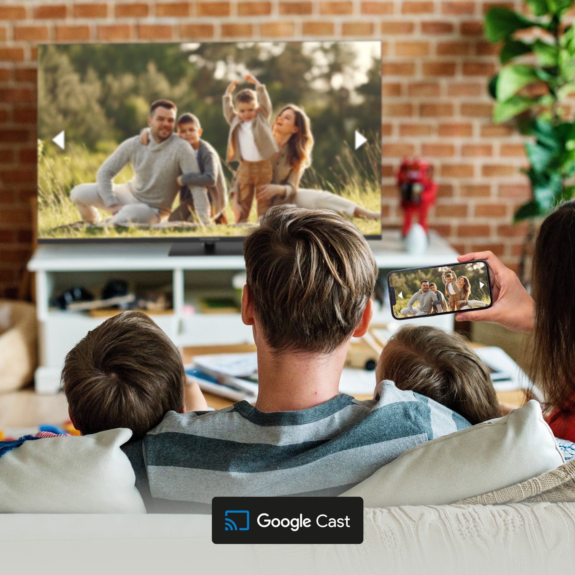 Family watching a video on a TV with a smartphone showing the same content, in a cozy living room.